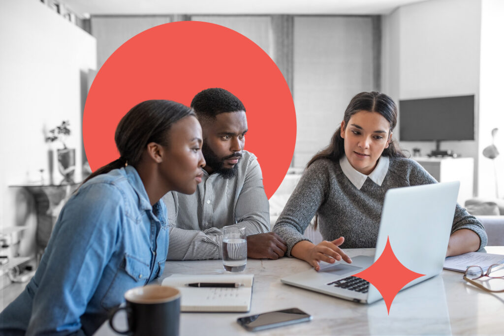 Financial planner going over savings plans on a laptop with a young African American couple at a table in their living room at home